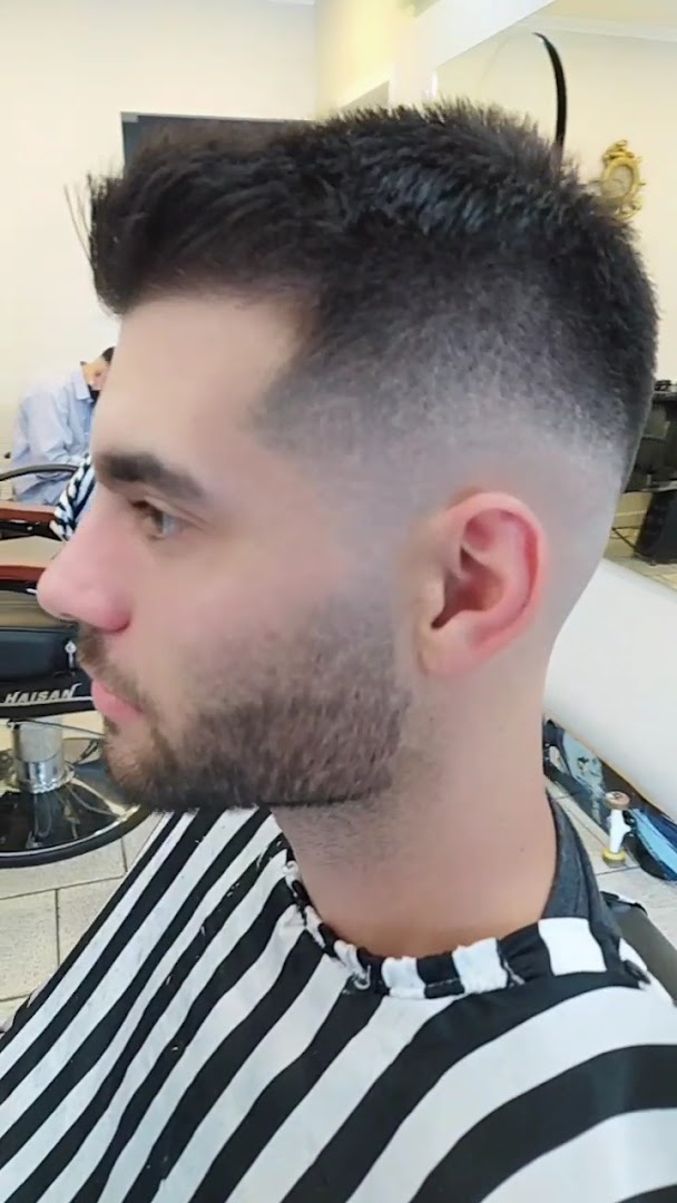 Corte com topo texturizado e fade, cliente na cadeira da barbearia